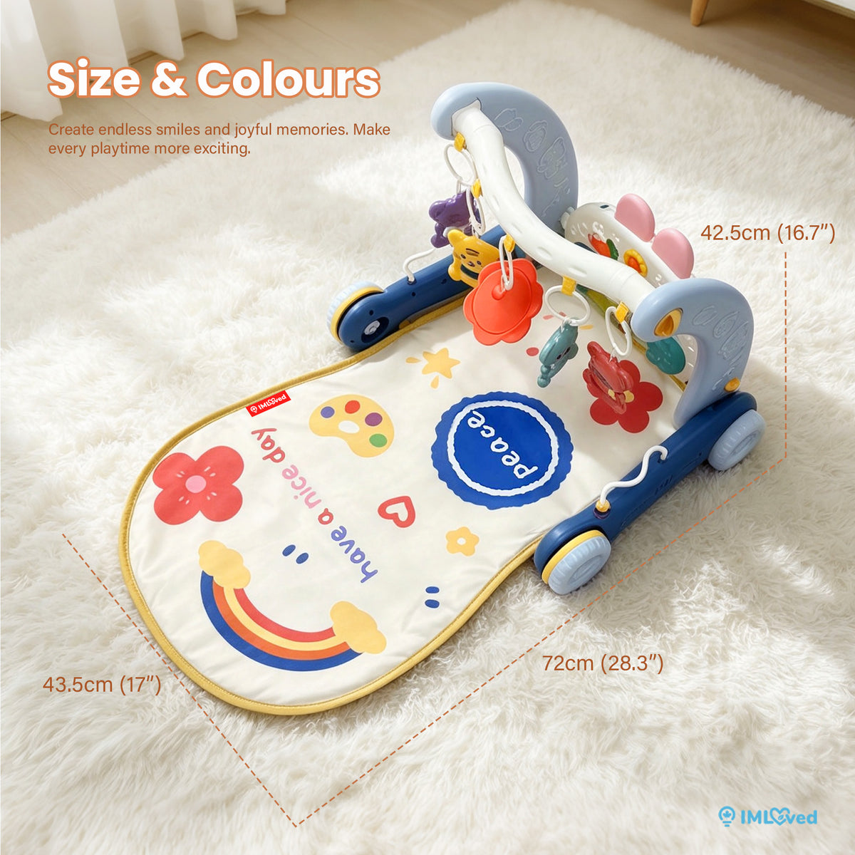 A baby activity gym mat with a wheeled base, shown on a white faux-fur rug with overlaid dimension lines and text indicating size measurements. The mat is cream with blue, yellow, red, and multicolor printed graphics and text, including a rainbow, flowers, hearts, and a blue circle reading 'peace'.