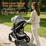 A woman in a cream sweater and pants pushes a large black and gray stroller on a paved path in a park. Promotional text at the top highlights extra-large storage capacity, and an IMLoved logo appears in the bottom left corner.